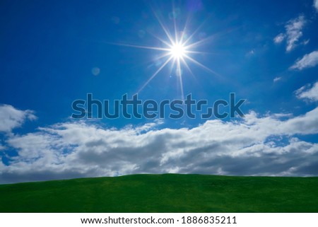 Grass hills on horizon in steppe under white clouds sky during sunset with sun light beams.  nature background. summer or spring season. empty copy space for inscription. Grassland. straight horizon