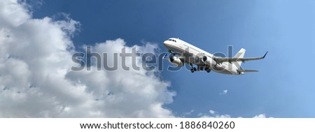 Zoom ultra wide photo as seen from the ground of Airbus A320 passenger airplane taking off in deep blue  slightly cloudy sky