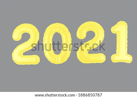 Yellow Christmas 2021 balloons on gray background. Numbers for New Year 2021. Party decoration.
