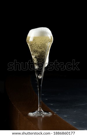 Champagne is poured into a beautiful glass on a dark background