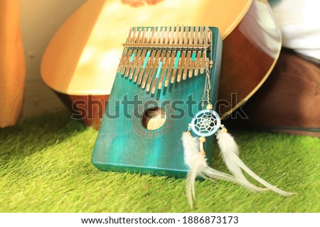 Kalimba or mbira is an African musical instrument.Traditional small Kalimba made from  wooden board with metal, play on  hands and plucking the tines with the thumbs. Instrument in room