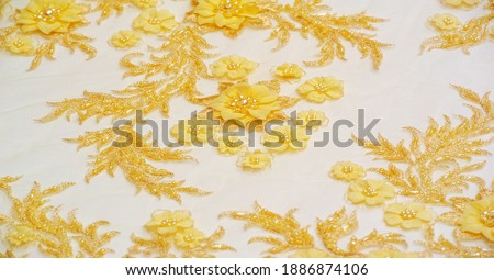 The lace is yellow. Texture. background. template. This is a high quality yellow gold sequined embroidery stitching sewn on gold mesh lace fabric. use for postcard, poster, texture or wallpaper