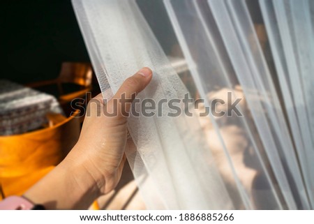 Woman hand on the curtain, stock photo