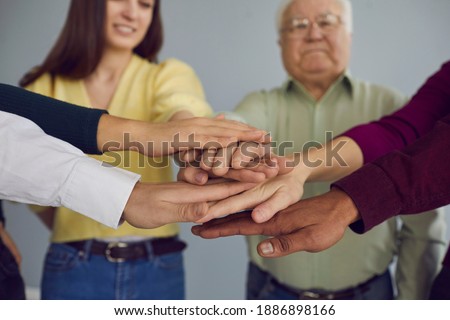 One for all, all for one. Group of diverse young and mature people putting hands together, supporting each other. Unity, common effort, participation, bonding concept. Soft selective focus, close-up Royalty-Free Stock Photo #1886898166
