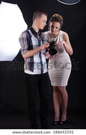 Model and photographer analysing the picture on a screen of digital camera