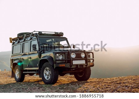 Dark green off-road car in the mountains Royalty-Free Stock Photo #1886955718