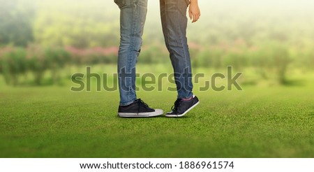 Couple kissing, girls stands on tiptoe to kiss her man, legs of a guy and a girl they kiss