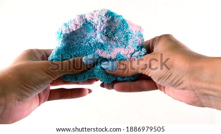 Female hands are molded from light airy multicolored blue plasticine, developing activities for children