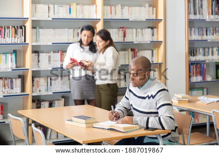 Adult male student working in library, concept of adult education