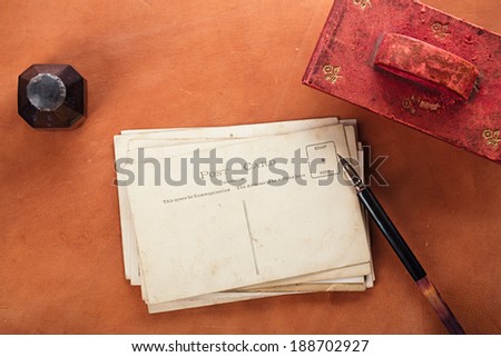 vintage red leather ink blotter  with retro post cards on leather table, shallow dof