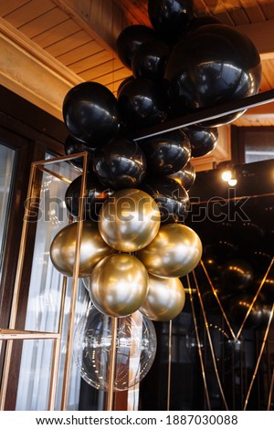 Wedding or birthday photo zone with white, black and gold balloons indoors. Holiday party decoration. Colorful balloons background. Valentines day