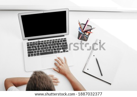 school at home through online homeschooling. the child is sitting at the computer