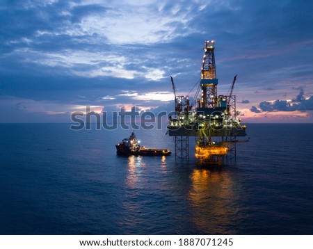 Aerial view offshore drilling rig (jack up rig) at the offshore location during sunset Royalty-Free Stock Photo #1887071245