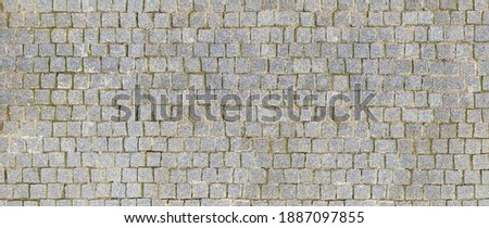 Granite cobblestoned pavement background. Stone pavement texture. Abstract background of cobblestone pavement close-up. Seamless texture. Royalty-Free Stock Photo #1887097855