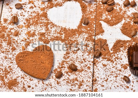 sweet food top view background for merry christmas or new year holiday decoration - coffee beans, heart and star shapes from cocoa powder on white wood