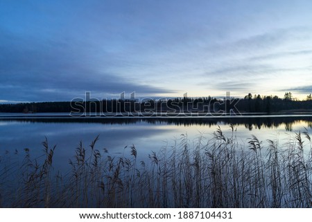 Sunset at lake in Katrineholm Sweden. Colorful winter evening at dusk. Beautiful scandinavian nature and landscape. Calm, peaceful photo.