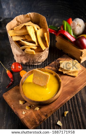 chips with sauce and vegetables on a dark wooden table