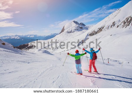 Happy family - mother and son enjoying winter vacations in mountains . Ski, Sun, Snow and fun.