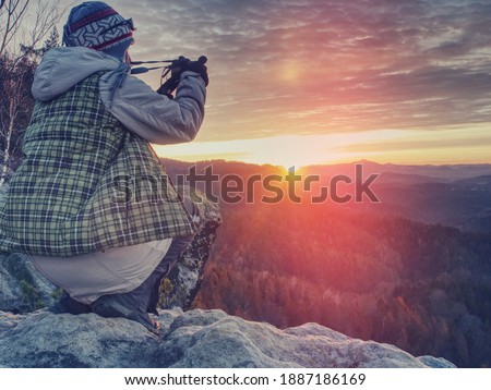 Nature still photography photographer woman with professional slr camera taking picture of fall daybreak. Abstract filter.