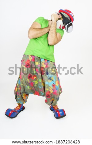 Holiday and fun concept. The clown plays, he has virtual glasses on his head, fights - defends himself. Isolated on white