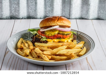 Fast food cheeseburger and French fries.