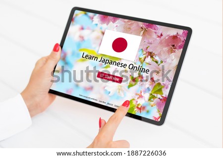 Person taking online courses on tablet to learn Japanese language