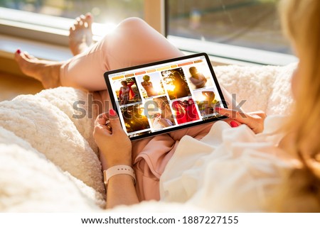 Woman sitting at home and browsing beautiful portrait photos online