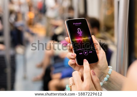 Woman listening to podcast on her phone while riding in public transport Royalty-Free Stock Photo #1887229612