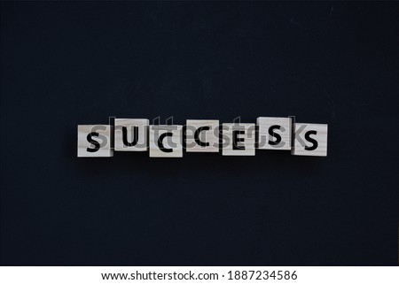 Success wording on wood block concept with black background. 