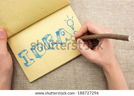 Notepad with hand drawing sketchy Idea word with light bulb 