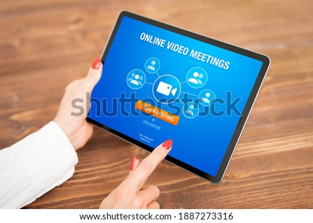 Woman using online video meeting app on tablet computer