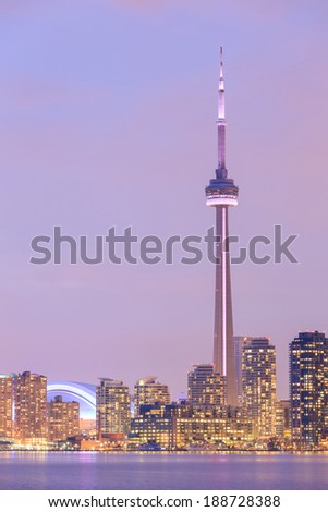 Toronto city dusk over lake with colorful light.