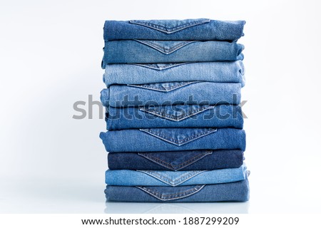 Jeans trousers stack   on a white background concept jeans in supermarket and shop.
 Royalty-Free Stock Photo #1887299209