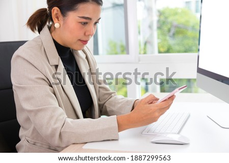 Close up of female hands scrolling on smartphone and working from home. Workplace in home office with PC, devices and gadgets. Concept of distance learning, shopping online.