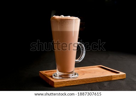 Hot chocolate with marshmallows isolated on black background. Glass of cocoa over black. Hot winter drink.