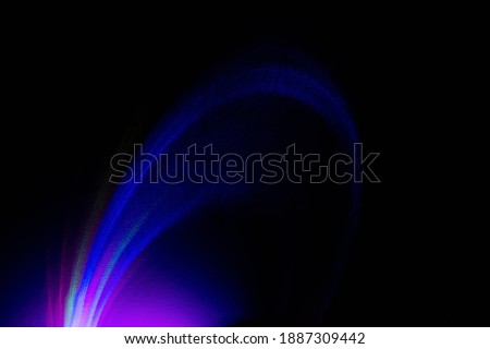 Fluorescent background. UV radiance. Defocused colorful blue purple magenta pink neon light glowing curve rays on dark black abstract futuristic wallpaper with empty space.