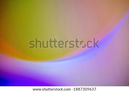 Holographic art background. Color gradient. Blur blue purple fluorescent neon light iridescent curve lines illumination on defocused pink yellow copy space abstract banner with grain texture.