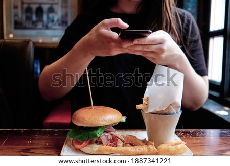 Unrecognizable woman taking a photo of her lunch on her phone. Food photography.