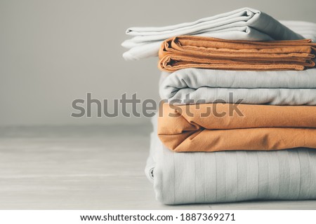 Stack of clean bed sheets on table Royalty-Free Stock Photo #1887369271