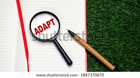 Word ADAPT written on notebook red letters. Conceptual photo