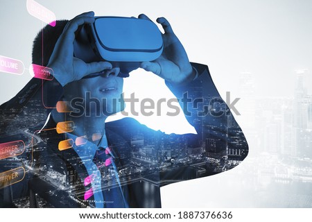 Portrait of young European businessman using VR glasses in blurry night city. Concept of hi tech and communication. Toned image double exposure