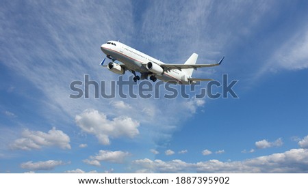 Zoom photo of passenger airplane taking off in deep blue  slightly cloudy sky as seen from the ground 