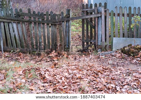 Old fence in the countryside with broken pickets. Selective focus.