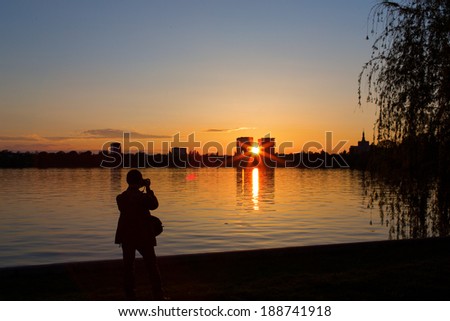 Amateur photographer taking pictures on sunset