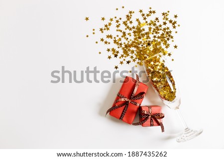 Christmas or new year background with gift boxes and glass of golden glitters, abstract celebration concept. flat lat arrangement with copy space.