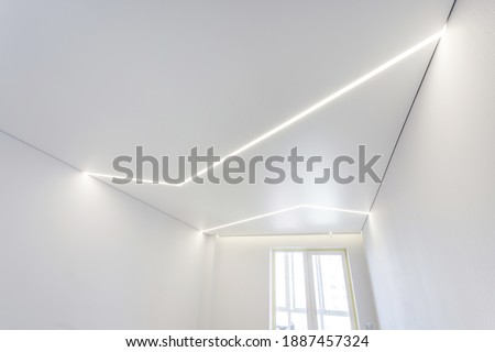 suspended ceiling with halogen spots lamps and drywall construction in empty room in apartment or house. Stretch ceiling white and complex shape. Royalty-Free Stock Photo #1887457324