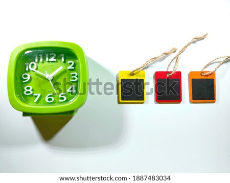 Selective focus.Copy and text space on a wooden board with clock on a white background.Shot were noise and film grain in full resolution.