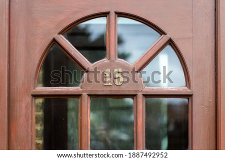 Fifteen in metal digits on a brown wooden front door