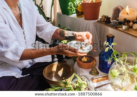 Stock photo of natural therapist preparing plants and oil for massage.