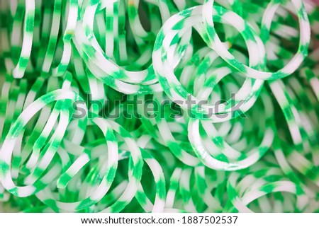 A set of and green elastic bands for weaving children's bracelets or charms. 